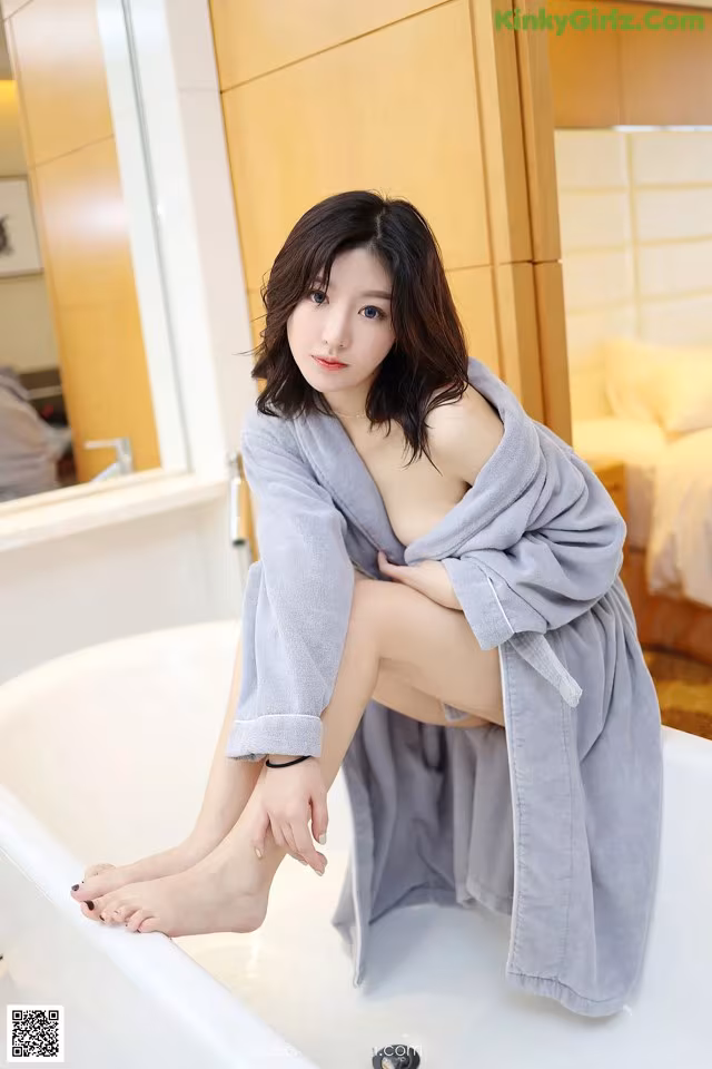 A woman sitting in a bathtub with her legs crossed.