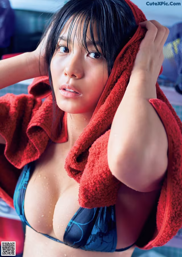 A woman in a bikini with a red towel wrapped around her head.
