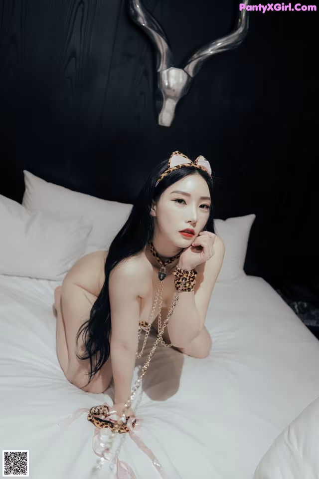 A woman laying on a bed wearing a leopard print headband.