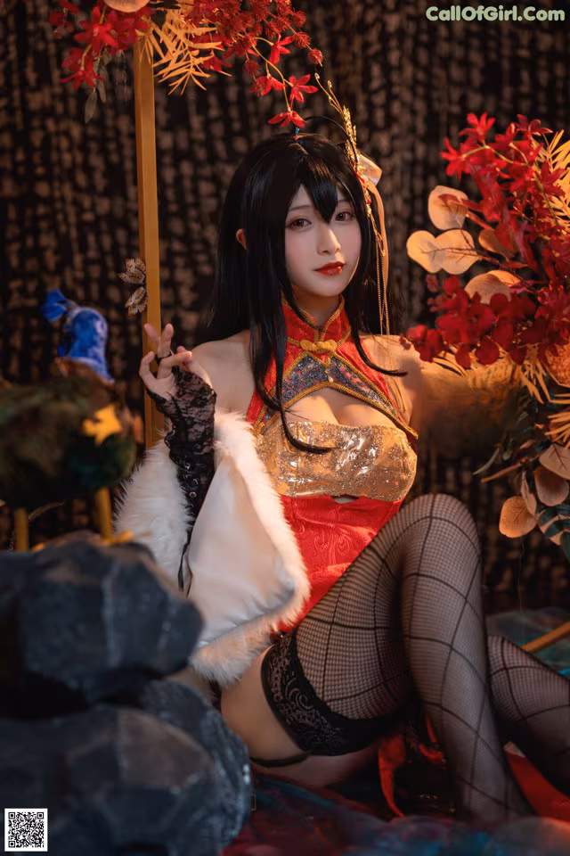 A woman in a red and gold outfit sitting on a bed.
