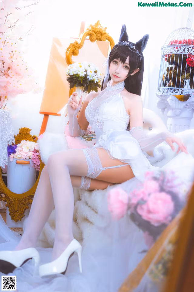 A woman in a white dress sitting on a white chair.