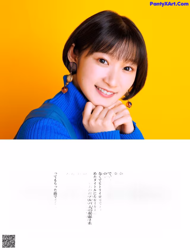 A woman in a blue sweater is posing for a magazine.