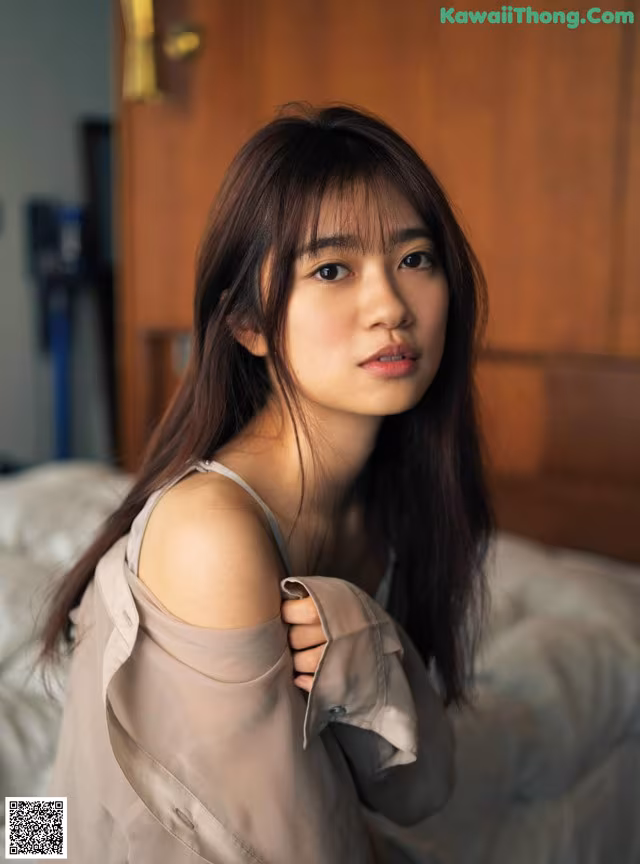 A woman sitting on top of a bed next to a door.