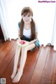 A woman sitting on the floor holding a slice of watermelon.