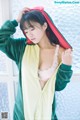 A woman in a green and yellow robe is posing for a picture.