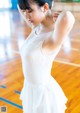 A woman in a white leotard standing on a basketball court.