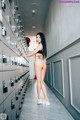 A woman standing in front of a bunch of lockers.