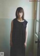 A woman in a black dress standing in front of a door.
