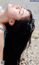 A woman laying on the beach with her eyes closed.